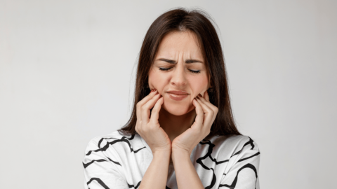 Woman with tooth pain holding her jaw