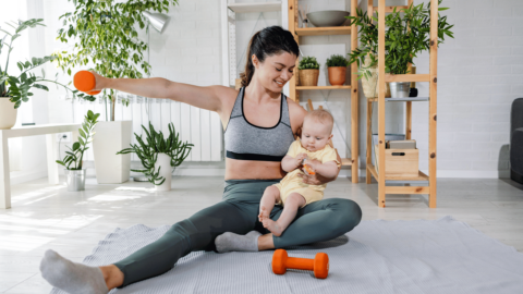 New mom doing light exercise at home with her baby while on a GLP-1 weight loss plan, promoting healthy postpartum habits