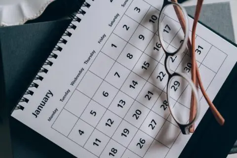 a pair of reading glasses on a calendar