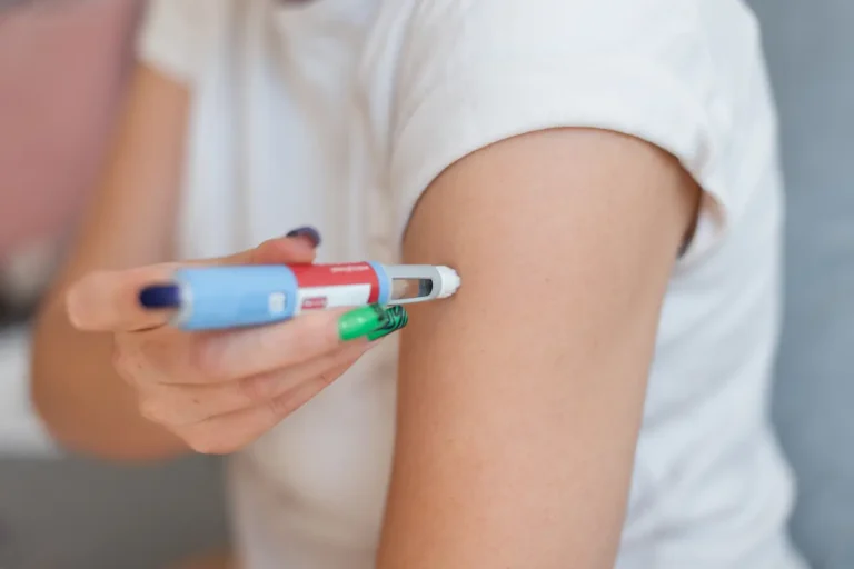 Person self-administering a GLP-1 injectable medication pen into their upper arm