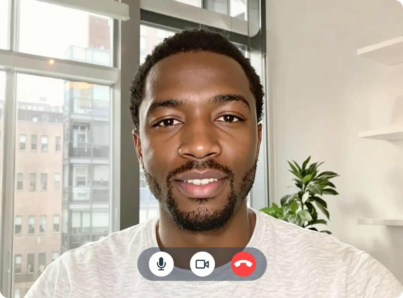Man smiling during a telehealth video call with microphone, camera, and end call controls visible