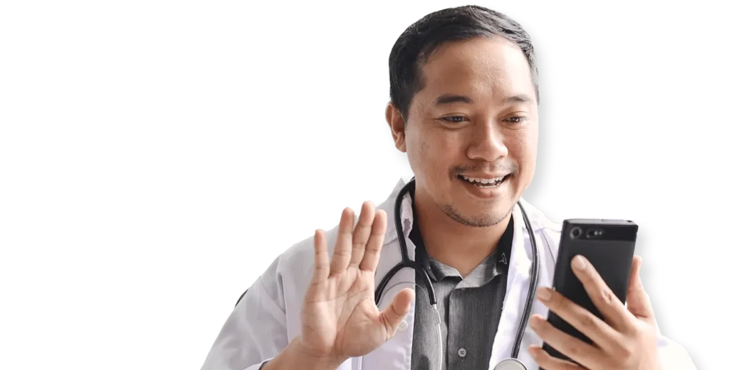 Smiling doctor in white coat with stethoscope waving during a telehealth video consultation on smartphone