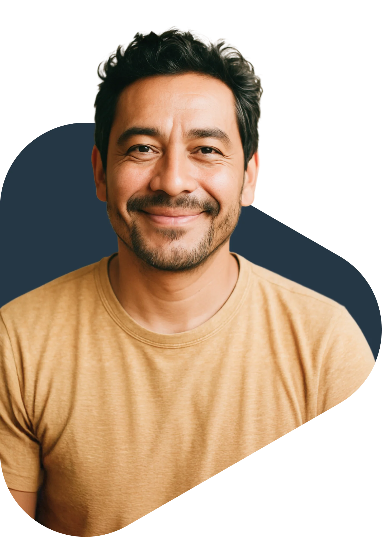 Smiling middle-aged man with dark hair and beard wearing a tan t-shirt against a navy blue background