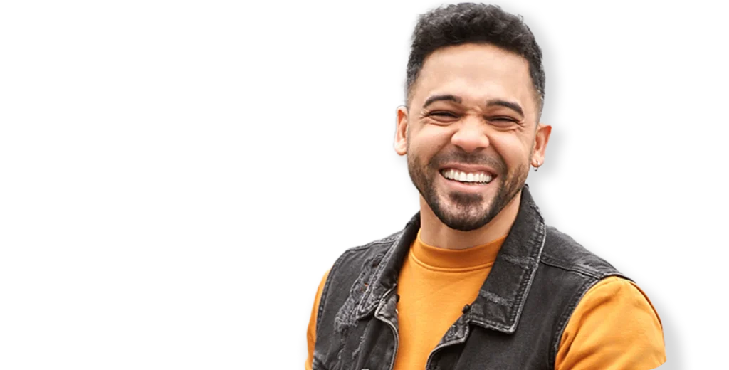 Happy young man smiling confidently after weight loss, wearing an orange shirt and denim vest