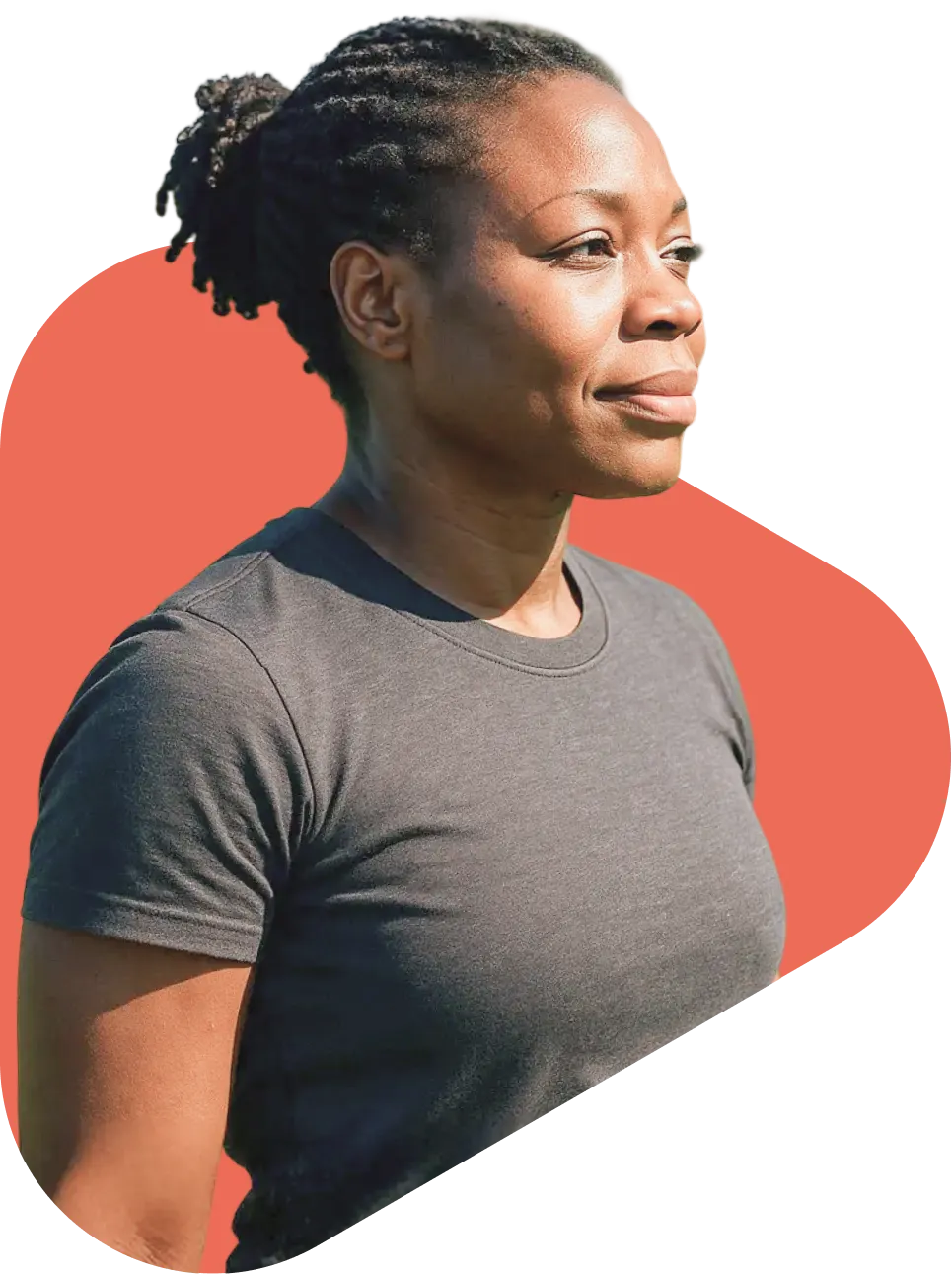 Side profile of a confident Black woman with braided updo wearing a gray t-shirt, gazing forward against a red background.