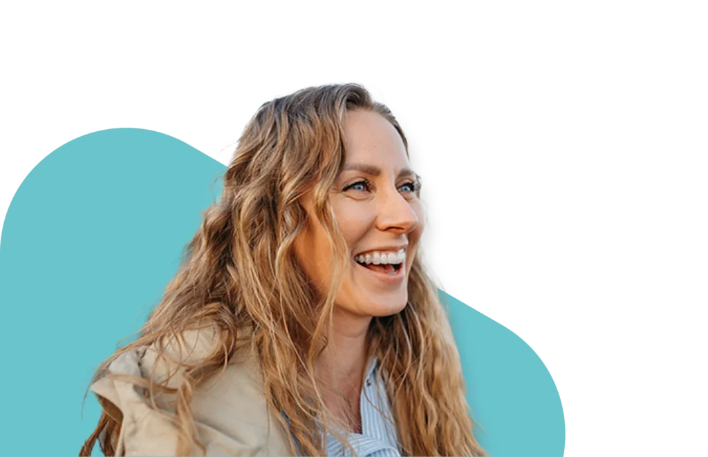 Smiling woman in a beige jacket after opioid addiction recovery with QuickMD