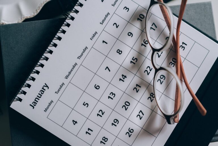 a pair of reading glasses on a calendar