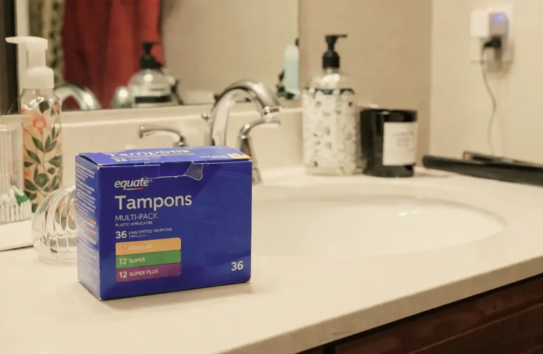 Equate multi-pack tampons box with 36 unscented tampons on a bathroom counter, representing perimenopause and abnormal bleeding.