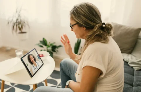 woman-speaking-to-doctor-online-in-living-room